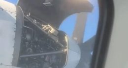 Airplane engine cover open mid-flight.