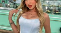 Portrait of a young woman in a light blue corset top and white pants.