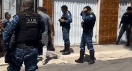 Police officers outside a house.