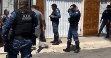 Police officers outside a house.