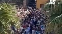 Large crowd of tourists overwhelming a narrow street in Sirmione.