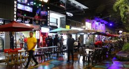 Night scene in Medellin, Colombia, showing tourists at outdoor cafes and hookah bars.