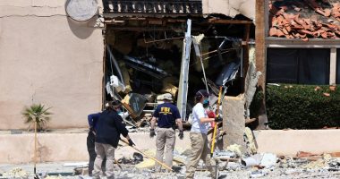 FBI agents collecting evidence at a bomb-damaged reproductive health facility.