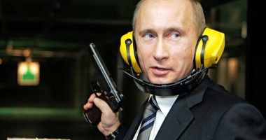 Vladimir Putin at a shooting range, holding a handgun.