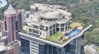 Aerial view of a mansion atop a skyscraper.