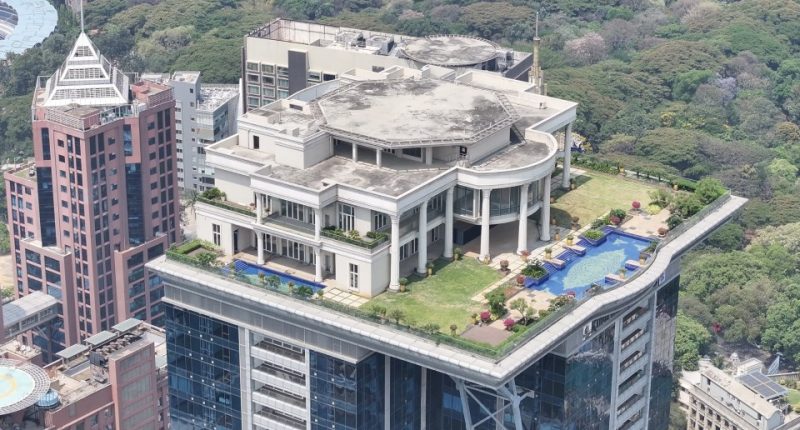 Aerial view of a mansion atop a skyscraper.