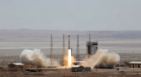 Rocket launching from a desert launchpad.