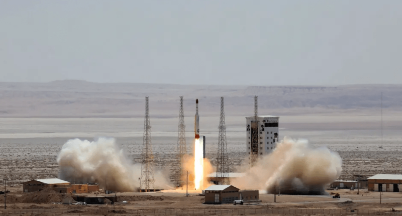 Rocket launching from a desert launchpad.