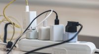 Electrical outlet with many chargers connected to it for a smartphone, laptop, microphone. (Getty Images)