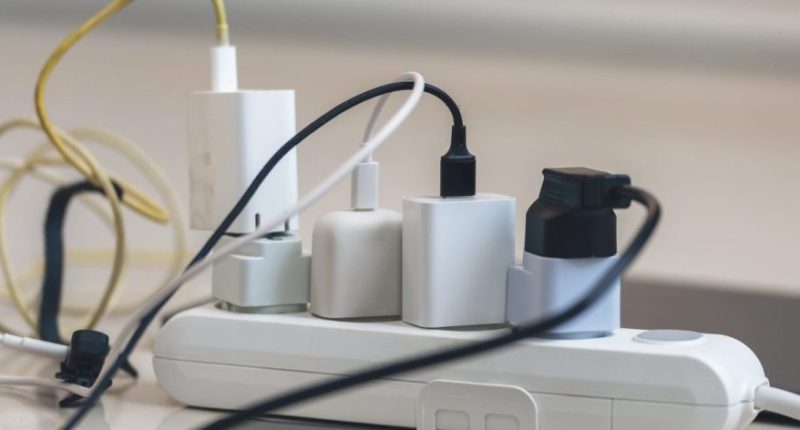 Electrical outlet with many chargers connected to it for a smartphone, laptop, microphone. (Getty Images)