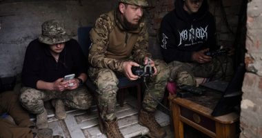 Ukrainian drone operators operating equipment in a makeshift command post.