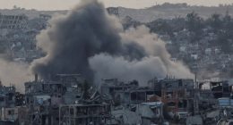 Smoke rises over destroyed buildings in Gaza following an explosion.
