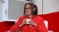 Kat Timpf in a red jacket holding a mug.