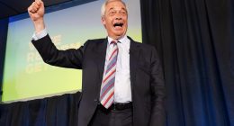 Nigel Farage celebrating on stage after Reform UK's election win.