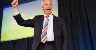 Nigel Farage celebrating on stage after Reform UK's election win.