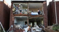 Residents surveying the damage to their tornado-destroyed home.