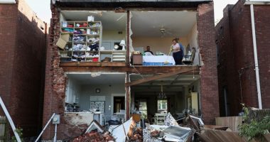 Residents surveying the damage to their tornado-destroyed home.