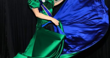 Lady Gaga in a green and blue satin gown backstage.