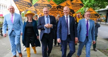 Ed Davey and other Liberal Democrat candidates and supporters walking while campaigning.
