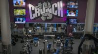 People wearing masks work out at a Crunch Fitness gym.