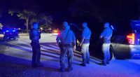 Police officers at a nighttime crime scene.