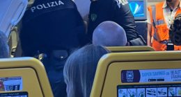 Police officers removing disruptive passengers from an airplane.