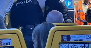 Police officers removing disruptive passengers from an airplane.