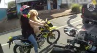 Woman riding motorcycle with dog.