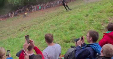 Contestant performing a somersault during a cheese rolling competition.