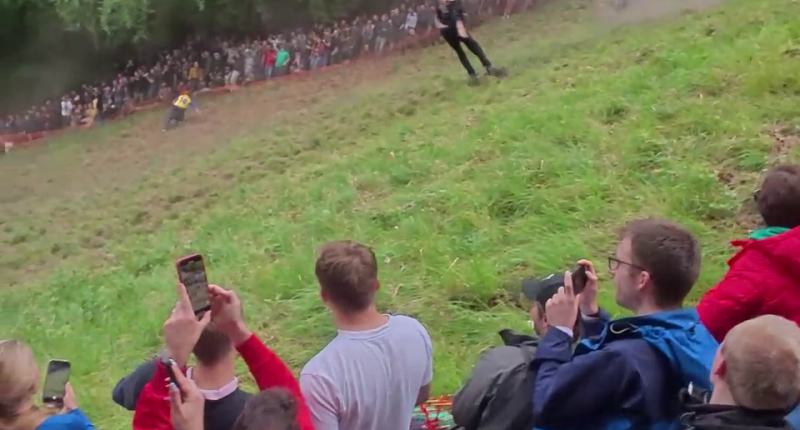 Contestant performing a somersault during a cheese rolling competition.