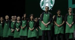 Starbucks baristas stand on stage, March 20, 2019, during an annual shareholders meeting in Seattle. (AP Photo/Ted S. Warren, file)
