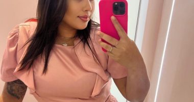 Woman taking a selfie in a pink outfit.