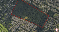 Aerial view of a 120-acre plot of land proposed for a 496-unit apartment complex.