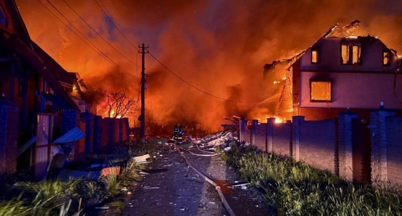 Firefighters battling a fire in a residential area following a Russian attack.