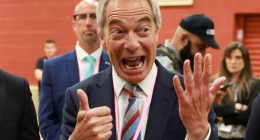Nigel Farage giving a thumbs-up and raising his other hand.
