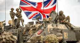 British soldiers with a Union Jack on a military vehicle.
