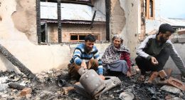 A family surveys the damage to their home after shelling.