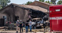 NTSB and FAA investigators at the site of a plane crash that damaged a home and vehicle.