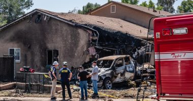 NTSB and FAA investigators at the site of a plane crash that damaged a home and vehicle.