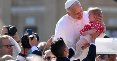 Pope Leo XIV holding a baby.