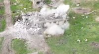 Aerial view of a building being destroyed by an explosion.