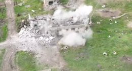 Aerial view of a building being destroyed by an explosion.