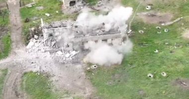 Aerial view of a building being destroyed by an explosion.