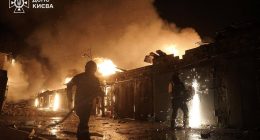Ukrainian firefighters extinguishing a fire at a missile attack site in Kyiv.