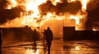 Firefighters battling a large fire at a gas station.