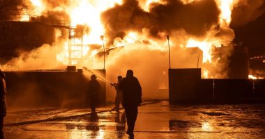 Firefighters battling a large fire at a gas station.