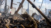 Firefighters at the site of a damaged warehouse after a drone attack.