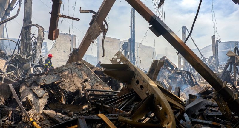 Firefighters at the site of a damaged warehouse after a drone attack.