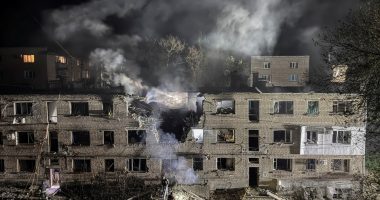 Apartment building damaged by a drone strike at night.