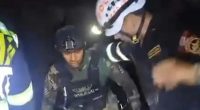 Security personnel assisting a person in a dark setting.